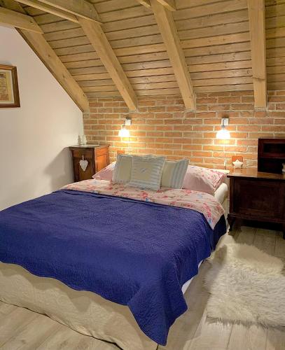 a bedroom with a bed with a brick wall at Family friendly house with a swimming pool Novi Marof, Zagorje - 19184 in Novi Marof