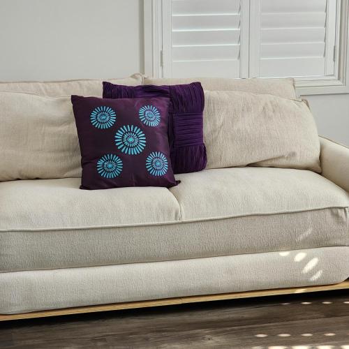 a brown couch with a purple pillow on it at Rooms at Gables in a modern home in Annangrove