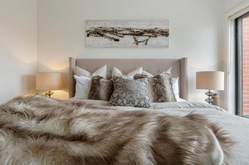 a bedroom with a large bed with a faux fur blanket at VAQUAY Contempo In Flemington in Melbourne
