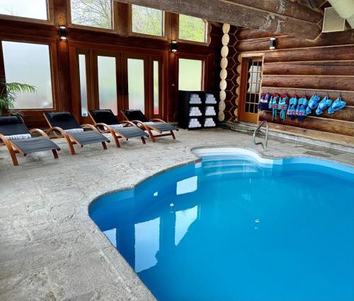 - une grande piscine dans une pièce avec des chaises dans l'établissement Family fun private outdoor hot tub, à Mille-Isles