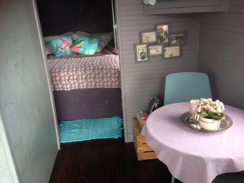 um pequeno quarto com uma mesa e uma cama em Une roulotte à la campagne em Saint-Just-et-Vacquières