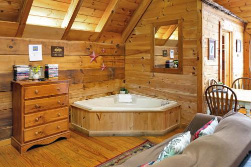 Habitación de madera con baño con bañera. en Cozy Cabin! Hot Tub, King Bed, Fireplace, & Pool en Gatlinburg