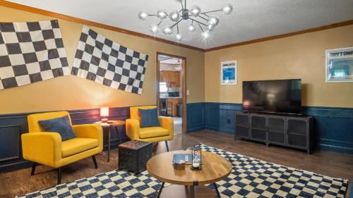 a living room with yellow chairs and a television at 4bd Contemporary Home with BBQ, Game Room in Charlotte