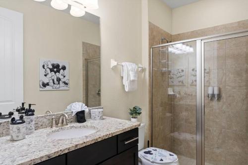 La salle de bains est pourvue d'une douche, d'un lavabo et de toilettes. dans l'établissement Lovely Disney-Themed Family Retreat Pool Theater, à Orlando