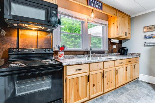 a kitchen with a black stove and a sink at 3 Mi to Downtown Home with Fire Pit in Forest City in Forest City