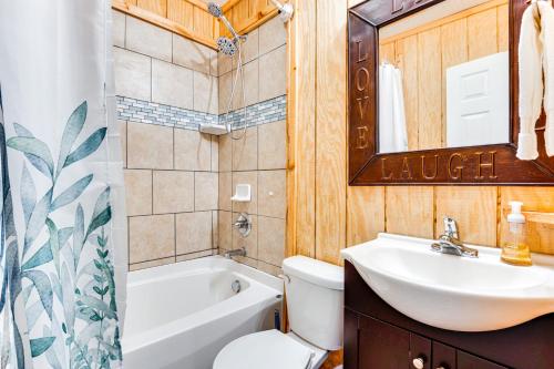 a bathroom with a sink and a toilet and a mirror at 3 Mi to Downtown Home with Fire Pit in Forest City in Forest City