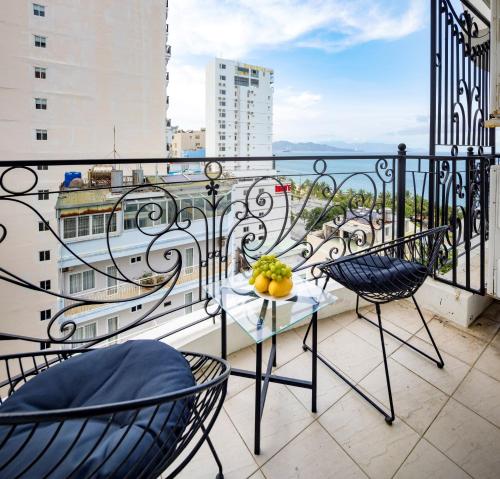 a balcony with a table with a bowl of fruit on it at Paris Luxury Hotel & Apartment Nha Trang in Nha Trang