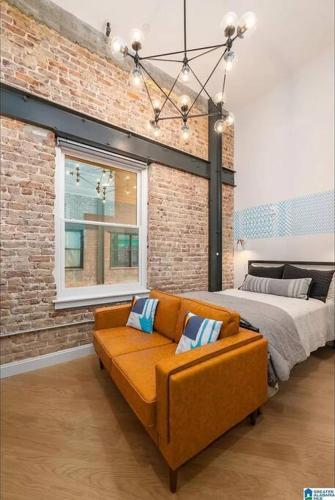 a bedroom with a bed and a couch in front of it at Mercantile industrial loft! in Birmingham