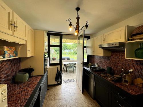 une cuisine avec des armoires blanches et un comptoir dans l'établissement Maison chaleureuse 160 m2 avec grand jardin, à Anzin