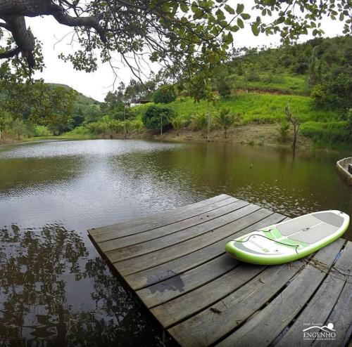a surfboard sitting on a dock next to a body of water at Apt Flat 225 Condomínio Pedra do Rodeadouro in Bonito