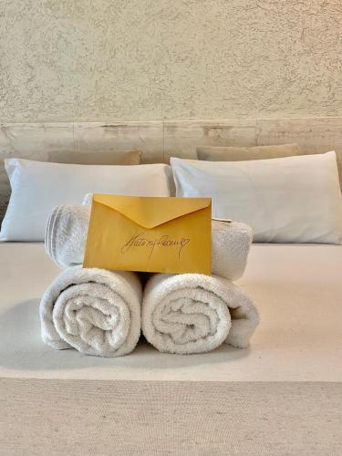 una pila de toallas y una caja en una cama en FUTURA ROOM&RELAX en Termoli