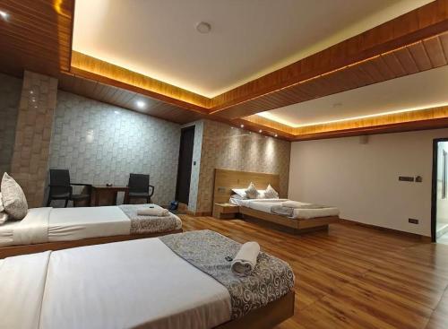 a hotel room with two beds and a table at Hotel Namgyal House in Gangtok