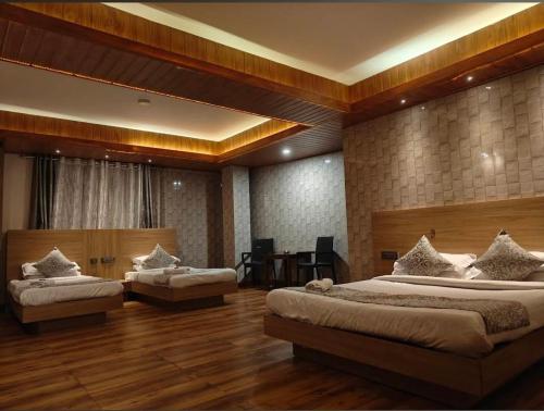 a large bedroom with two beds and a table at Hotel Namgyal House in Gangtok