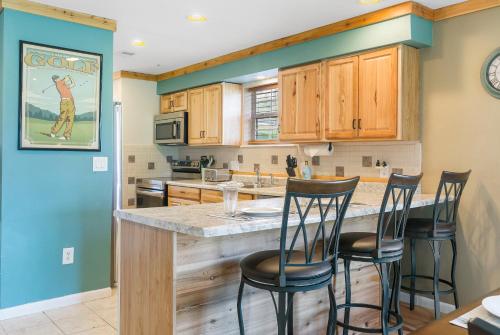 a kitchen with wooden cabinets and a counter with bar stools at Gorgeous lodge with a view in Branson