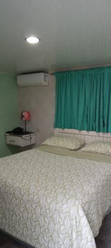 a bedroom with a bed and a blue window at Hotel Frano Romana Center in La Romana
