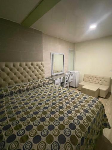 a bedroom with a large bed and a couch at Hotel Frano Romana Center in La Romana