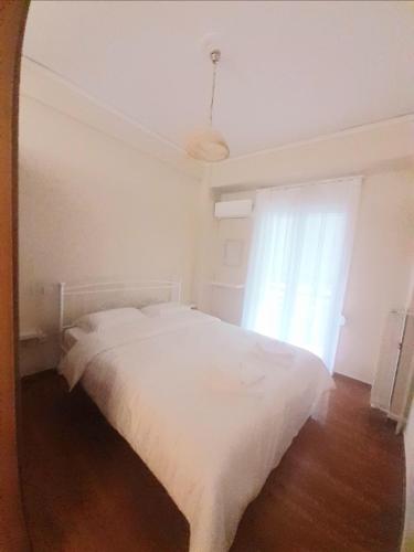 1 dormitorio con cama blanca y ventana en A-Apartments -- Agiou Therapontos, en Atenas