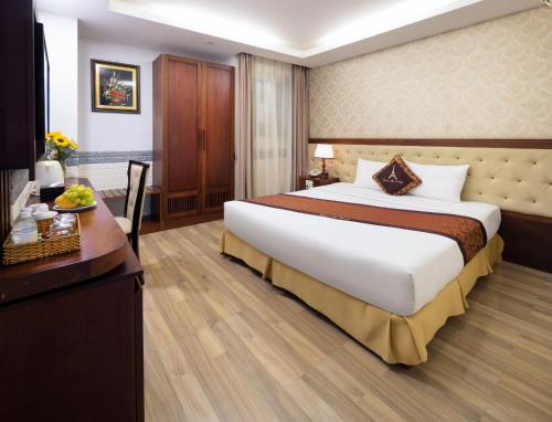 a hotel room with a large bed and a desk at Paris Luxury Hotel & Apartment Nha Trang in Nha Trang