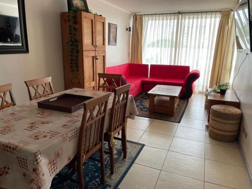 sala de estar con mesa y sofá rojo en Apartment La Serena Pacifico, en La Serena