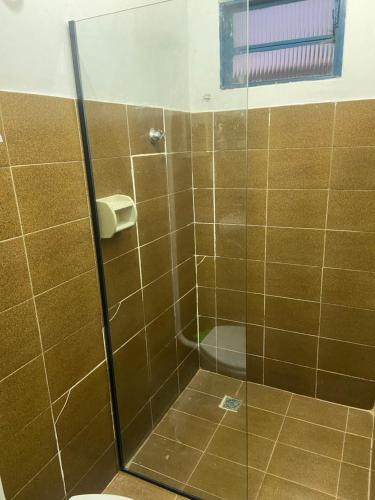 y baño con ducha de cristal y aseo. en Hospedaria São Jorge - Chapada dos Veadeiros en Sao Jorge