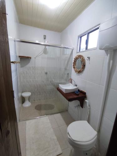 a bathroom with a shower and a toilet and a sink at Chácara Toca da Zuca in Divino de São Lourenço