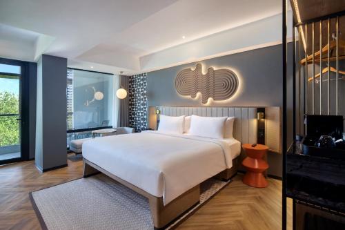 a hotel room with a large bed and a television at Tribe Bali Kuta Beach in Kuta