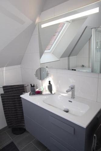 a bathroom with a white sink and a mirror at Kleine Auszeit 23 in Greetsiel