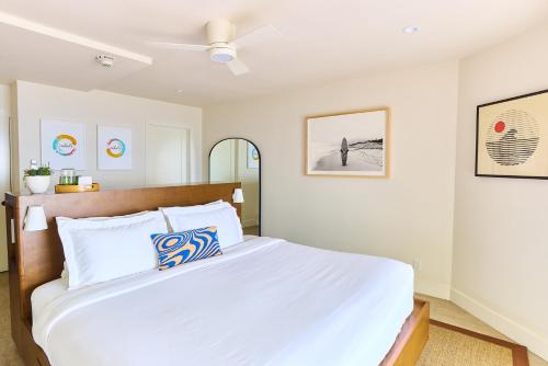 a bedroom with a white bed with a ceiling fan at Laguna Surf Lodge by SCP Hotels in Laguna Beach