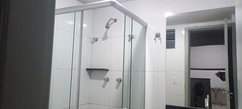 uma casa de banho com um chuveiro e um espelho. em Suíte no centro de Belo Horizonte em Belo Horizonte