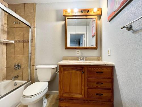 a bathroom with a toilet and a sink and a mirror at Spacious 2Beds Suite Close to Downtown and UC Davis Medical Center in Sacramento