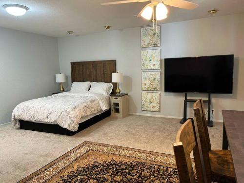 a bedroom with a bed and a flat screen tv at Spacious 2Beds Suite Close to Downtown and UC Davis Medical Center in Sacramento