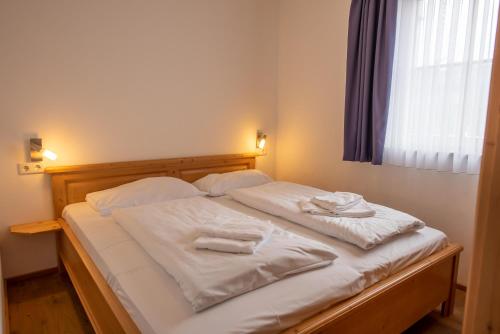 een bed met witte lakens en handdoeken erop bij Duxeranger D Top 2 in Krimml