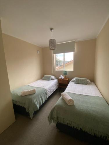 a bedroom with two beds and a window at Acogedor departamento completamente equipado in Villarrica
