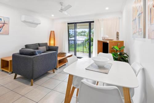 a living room with a table and a couch at Arlia Sands Apartments in Hervey Bay