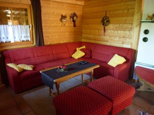 a living room with a red couch and a table at Schwabenhütte Top 1 in Krimml