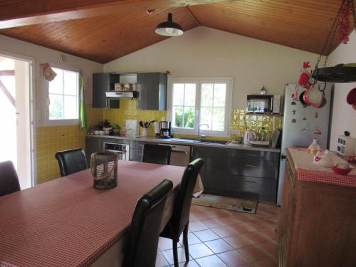 une cuisine avec une table et des chaises et une cuisine jaune dans l'établissement Maison familiale charmante avec jardin à La Faute-sur-Mer - FR-1-194-251, à La Faute-sur-Mer