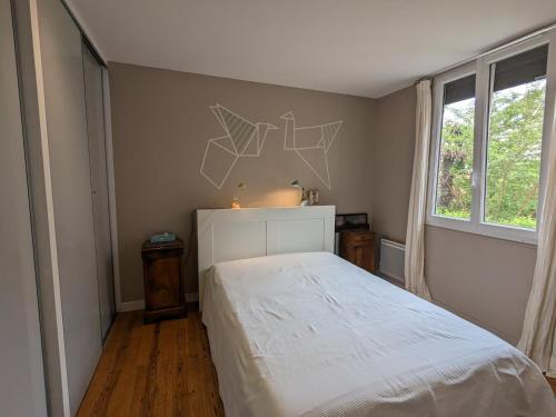 une chambre avec un lit blanc et une fenêtre dans l'établissement Appartement Calme au Centre d'Arcachon, Proche Plages, Commerces et Gare - FR-1-420-134, à Arcachon