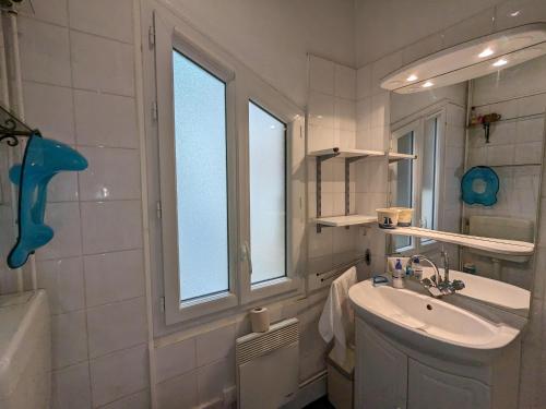 une salle de bain blanche avec un lavabo et une fenêtre dans l'établissement Appartement Calme au Centre d'Arcachon, Proche Plages, Commerces et Gare - FR-1-420-134, à Arcachon