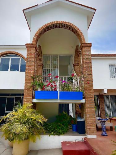 a building with a balcony with flowers on it at Adventure Inn La Paz in La Paz