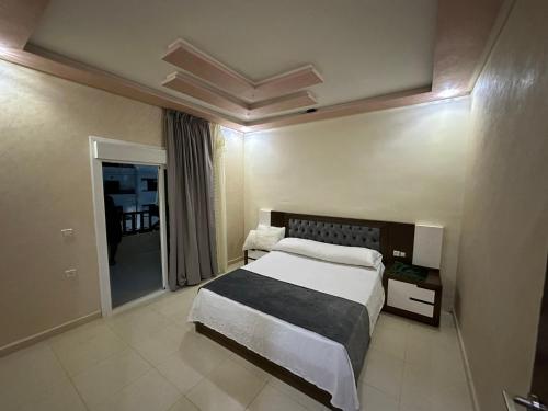 Tourist complex City Center Oued Laou في Oued Laou: غرفة نوم بسرير كبير ونافذة