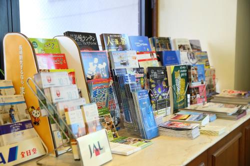 a display of books on a table with surfboards at Nagasaki IK Hotel in Nagasaki