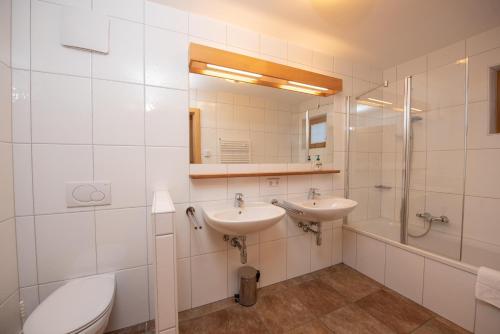 a bathroom with two sinks and a toilet and a shower at Almhäuser Filzsteinalpe Almhaus 201 in Krimml