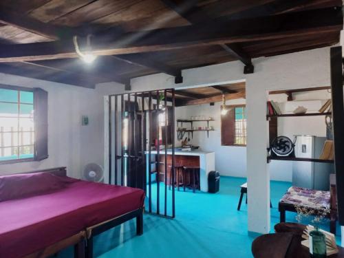 een slaapkamer met een bed en een kamer met blauwe vloeren bij Hostel Utopia in Holbox Island