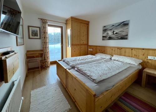 a bedroom with a large wooden bed in a room at Almhäuser Filzsteinalpe Almhaus 206 in Krimml