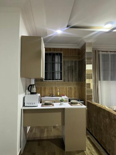 a kitchen with a sink and a microwave at Cozy Haven Suite in Accra