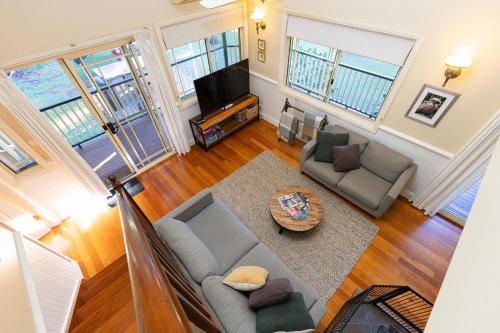 a living room with a couch and a tv at Telegraph Retreat Cottages in Telegraph Point