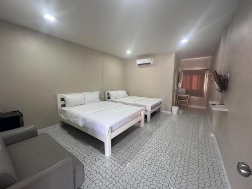 a room with two beds and a tv in it at Juni House Chumphon in Chumphon