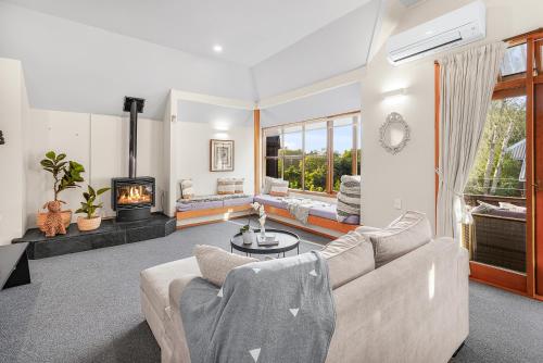 a living room with a couch and a fireplace at Tree Top Retreat in Central City - By KOSH BNB in Hamilton