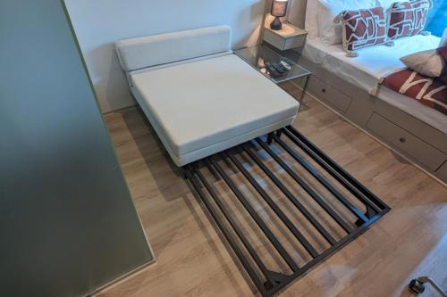 a room with a bench in the middle of a bed at Cosy City Studio Apartment in Melbourne