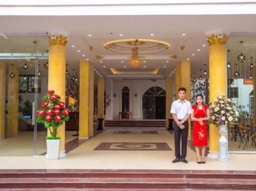 a man and a woman standing in front of a building at Hoàng Gia Hotel Sơn La in Sơn La